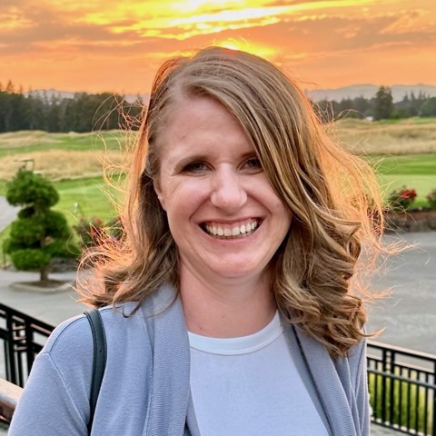 Katie smiling outdoors at sunset